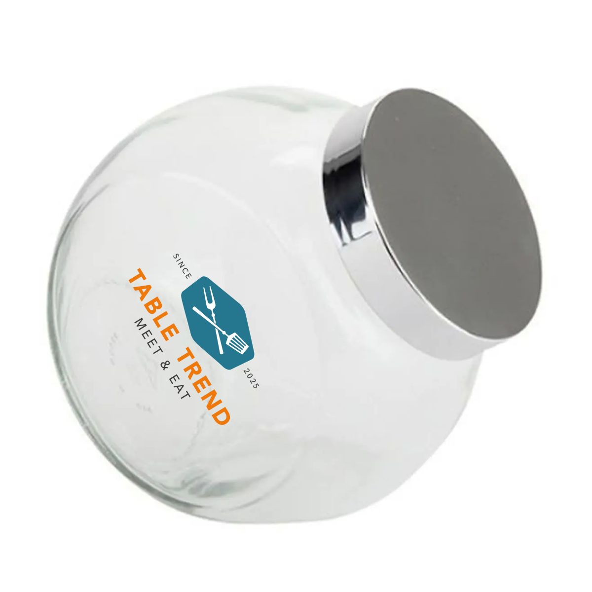 Snoeppot van glas met zilverkleurig deksel en meerkleurig TableTrend-logo op de voorzijde aangebracht.