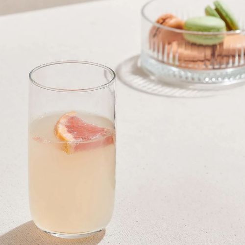 Sfeervolle setting met een gevulde glazen Iconic Tumbler 36,5 cl. inclusief zichtbaar logo op het oppervlak.