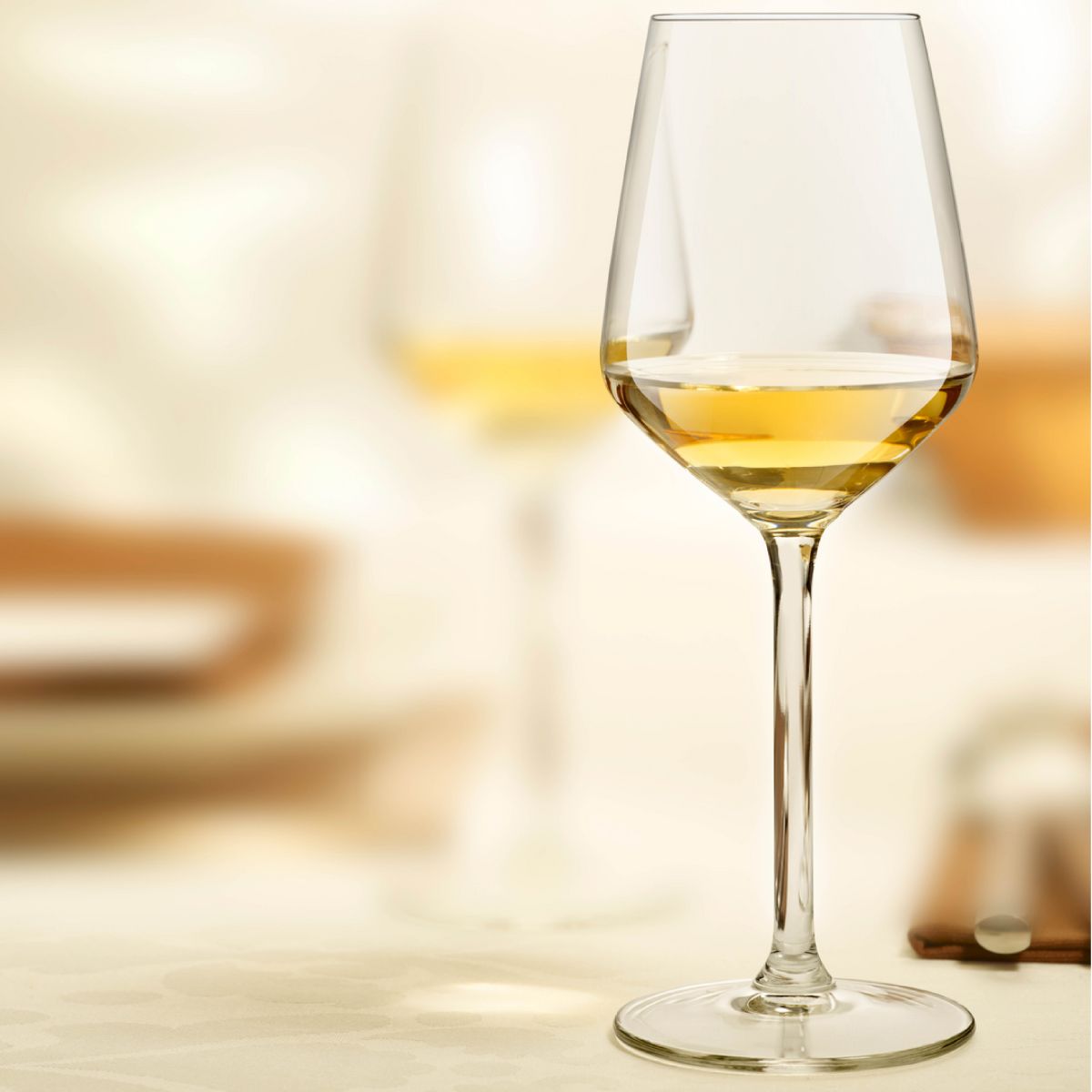 Carre wijnglas 29 cl. met drank en bedrukt logo, geplaatst in een sfeervolle setting.
