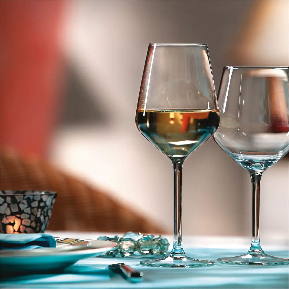 Carre wijnglas 38 cl. met drank in sfeervolle setting op tafel geplaatst.
