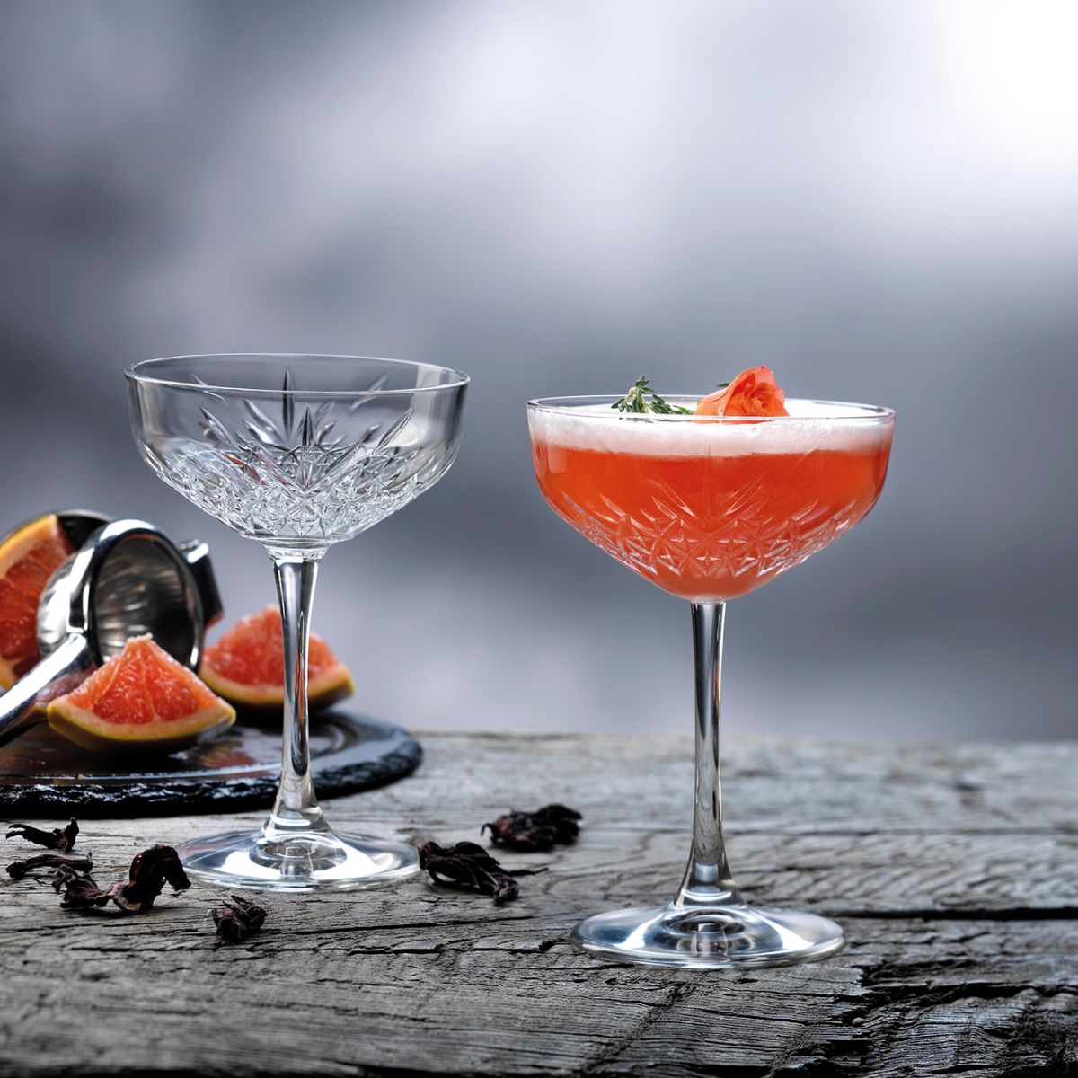 Timeless champagnecoupe 25,5 cl. met drankvulling, sfeervol gepresenteerd in een sfeeromgeving.