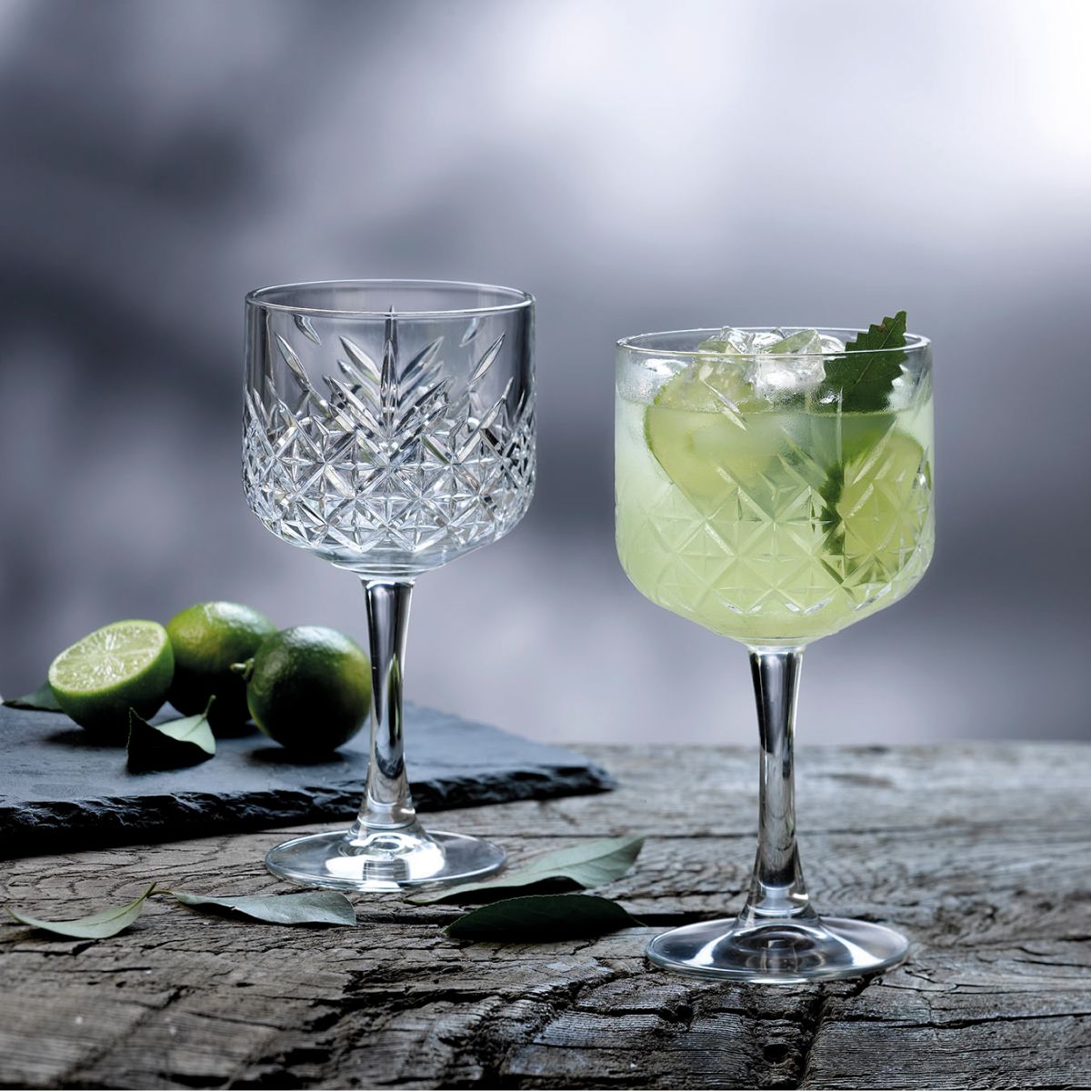 Gevuld Timeless Gin-Tonic glas 55 cl. in sfeervolle setting op tafel gepresenteerd.